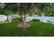 Artificial turf backyard with patio furniture under a large shade tree at 315 Princess St, Clearwater, FL 33755