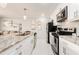 Modern kitchen with white cabinets, granite countertops, and stainless steel appliances at 2506 N Rocky Point Dr # 274, Tampa, FL 33607