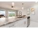Kitchen island with granite countertop, white cabinets, and stainless steel sink at 2506 N Rocky Point Dr # 274, Tampa, FL 33607