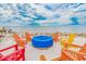 Beachfront fire pit with colorful Adirondack chairs at 2506 N Rocky Point Dr # 274, Tampa, FL 33607