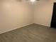 An empty bedroom with wood tile flooring and natural lighting at 3455 Countryside Blvd # 15, Clearwater, FL 33761
