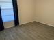 This bedroom has wood tile flooring and window with blinds at 3455 Countryside Blvd # 15, Clearwater, FL 33761