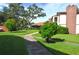 Exterior view of a well-kept condo, featuring green spaces and a paved walkway at 3455 Countryside Blvd # 15, Clearwater, FL 33761