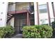 Inviting condo exterior featuring a private entrance, balcony, and lush landscaping at 3455 Countryside Blvd # 15, Clearwater, FL 33761