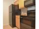 Functional kitchen with sleek black appliances and light wood cabinets for ample storage at 3455 Countryside Blvd # 15, Clearwater, FL 33761