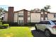 Brick condo building with a car parked in front and a well-maintained lawn at 3455 Countryside Blvd # 15, Clearwater, FL 33761