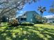 Back view of teal condo with screened patio and lawn at 182 114Th Ne Ter # 182, St Petersburg, FL 33716