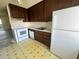 Bright kitchen features white appliances and dark brown cabinets at 182 114Th Ne Ter # 182, St Petersburg, FL 33716