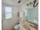 Tiled bathroom featuring a toilet, sink, medicine cabinet, and natural light from a window at 400 N Bayshore Blvd # 104, Clearwater, FL 33759