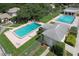 Aerial view of community pool area with two pools, lounge chairs, and a patio at 11837 Wildeflower Pl, Temple Terrace, FL 33617