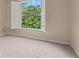 Bright bedroom with large window and neutral carpeting at 11837 Wildeflower Pl, Temple Terrace, FL 33617