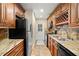 Galley kitchen with granite countertops and wood cabinets at 11837 Wildeflower Pl, Temple Terrace, FL 33617