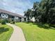 Paved walkway meanders through a grassy area towards condo building at 400 N Bayshore Blvd # 104, Clearwater, FL 33759