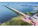 Aerial view of a serene pier extending over calm waters, with palm trees and seating area at 3108 58Th S St, Gulfport, FL 33707