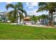 Front view of a teal Florida bungalow with palm trees and lawn at 3108 58Th S St, Gulfport, FL 33707
