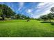 Golf course with a golf cart on a sunny day at 865 Maclaren N Dr # D, Palm Harbor, FL 34684