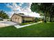 Exterior view of the house with a double garage and landscaping at 865 Maclaren N Dr # D, Palm Harbor, FL 34684