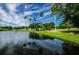 Serene golf course with a pond reflecting the palm trees at 865 Maclaren N Dr # D, Palm Harbor, FL 34684