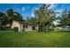 Landscaped backyard with lush lawn and mature trees at 865 Maclaren N Dr # D, Palm Harbor, FL 34684