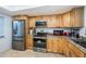 Modern kitchen with stainless steel appliances and wood cabinets at 865 Maclaren N Dr # D, Palm Harbor, FL 34684