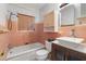 Bathroom with pink tile, updated vanity, and bathtub at 18053 2Nd E St, Redington Shores, FL 33708