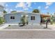 Light blue house with landscaped yard, driveway, and carport at 18053 2Nd E St, Redington Shores, FL 33708