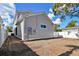Unlandscaped side yard with white vinyl fence at 3839 71St N St, St Petersburg, FL 33709