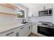 Bright kitchen with white cabinets, quartz countertops and stainless steel appliances at 135 Se Monroe N Cir, St Petersburg, FL 33703