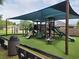 Community playground with shaded structure and play equipment at 2719 Mingo Dr, Land O Lakes, FL 34638