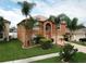Two-story house with palm trees and landscaped yard at 2719 Mingo Dr, Land O Lakes, FL 34638