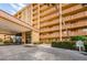 Front entrance of a condominium complex with covered driveway and landscaping at 9 Haig Pl # 312, Dunedin, FL 34698