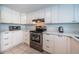 Kitchen boasts stainless steel appliances, white cabinets, and ample counter space at 9 Haig Pl # 312, Dunedin, FL 34698