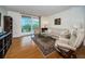 Living room with wood floors, comfortable seating, and sliding glass doors to a balcony at 9 Haig Pl # 312, Dunedin, FL 34698