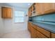 Efficient kitchen with wood cabinets and a light blue backsplash at 8693 Bardmoor Blvd # 202B, Seminole, FL 33777