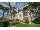 Two-story building with balconies, lush landscaping, and a grassy area at 8693 Bardmoor Blvd # 202B, Seminole, FL 33777