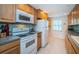 Clean and bright kitchen with white appliances and wood cabinets at 8693 Bardmoor Blvd # 202B, Seminole, FL 33777