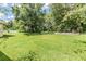 Spacious backyard with a large grassy area and retaining wall at 22531 Eagles Watch Dr, Land O Lakes, FL 34639