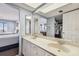 Bright bathroom featuring a double vanity and a large mirror at 14950 Gulf Blvd # 404, Madeira Beach, FL 33708