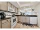 Bright kitchen with neutral cabinets, granite counters, and modern appliances at 14950 Gulf Blvd # 404, Madeira Beach, FL 33708