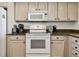 Bright kitchen featuring granite countertops and white appliances at 14950 Gulf Blvd # 404, Madeira Beach, FL 33708