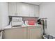 Practical laundry room with side by side washer and dryer and storage cabinets at 14950 Gulf Blvd # 404, Madeira Beach, FL 33708