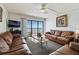 Inviting living room featuring leather sofas, ocean view balcony, and neutral decor at 14950 Gulf Blvd # 404, Madeira Beach, FL 33708