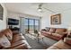 Inviting living room featuring leather sofas, ocean view balcony, and neutral decor at 14950 Gulf Blvd # 404, Madeira Beach, FL 33708