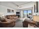 Bright living room with brown leather furniture and balcony access with ocean views at 14950 Gulf Blvd # 404, Madeira Beach, FL 33708