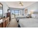 Stylish main bedroom with two beds, ocean view balcony, and wood furniture at 14950 Gulf Blvd # 404, Madeira Beach, FL 33708