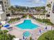 Stunning community pool and spa surrounded by lounge chairs and tropical landscaping at 14950 Gulf Blvd # 404, Madeira Beach, FL 33708