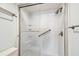 Updated shower featuring white tiled walls, glass door, and bronze fixtures at 14950 Gulf Blvd # 404, Madeira Beach, FL 33708