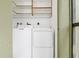 Bright laundry room with washer and dryer, and overhead shelving at 3300 Fox Chase N Cir # 231, Palm Harbor, FL 34683