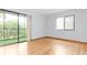 Bedroom with wood-look floors, sliding glass doors to a balcony, and a window at 3300 Fox Chase N Cir # 231, Palm Harbor, FL 34683