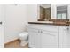 Bathroom with granite countertop, white cabinets, and toilet at 3300 Fox Chase N Cir # 231, Palm Harbor, FL 34683